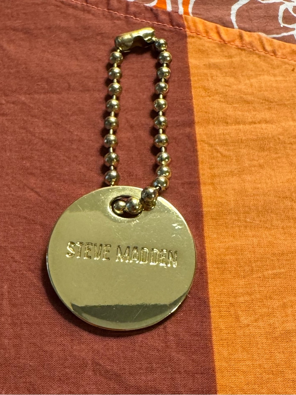 Steve Madden gold tone bag charm